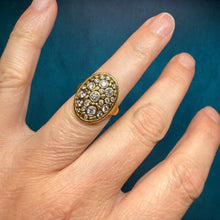 Load image into Gallery viewer, Gold ring with gemstones on a finger against a dark background