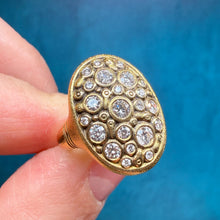 Load image into Gallery viewer, Gold ring with diamond accents held between fingers against a blue background